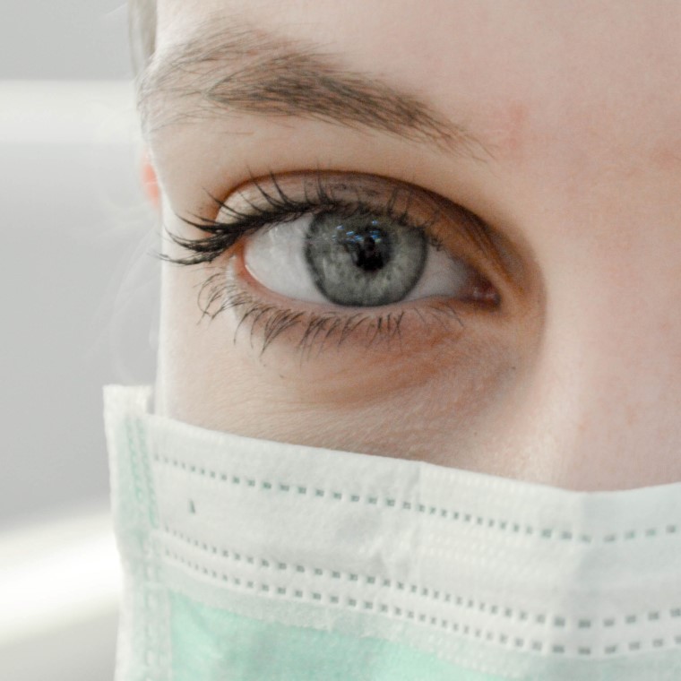 Face of woman who is wearing a mask.