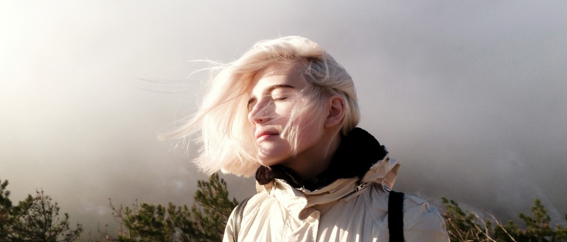 Young_woman_in_nature_1160x500.jpg Young woman in nature with a relaxed expression, closed eyes with the sun on her face.